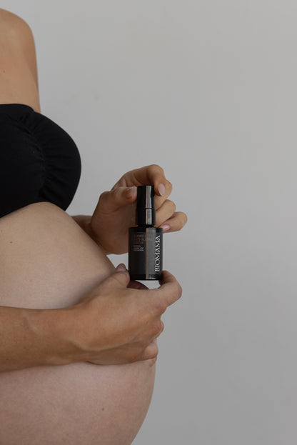 Pregnant woman holding anti-ageing serum