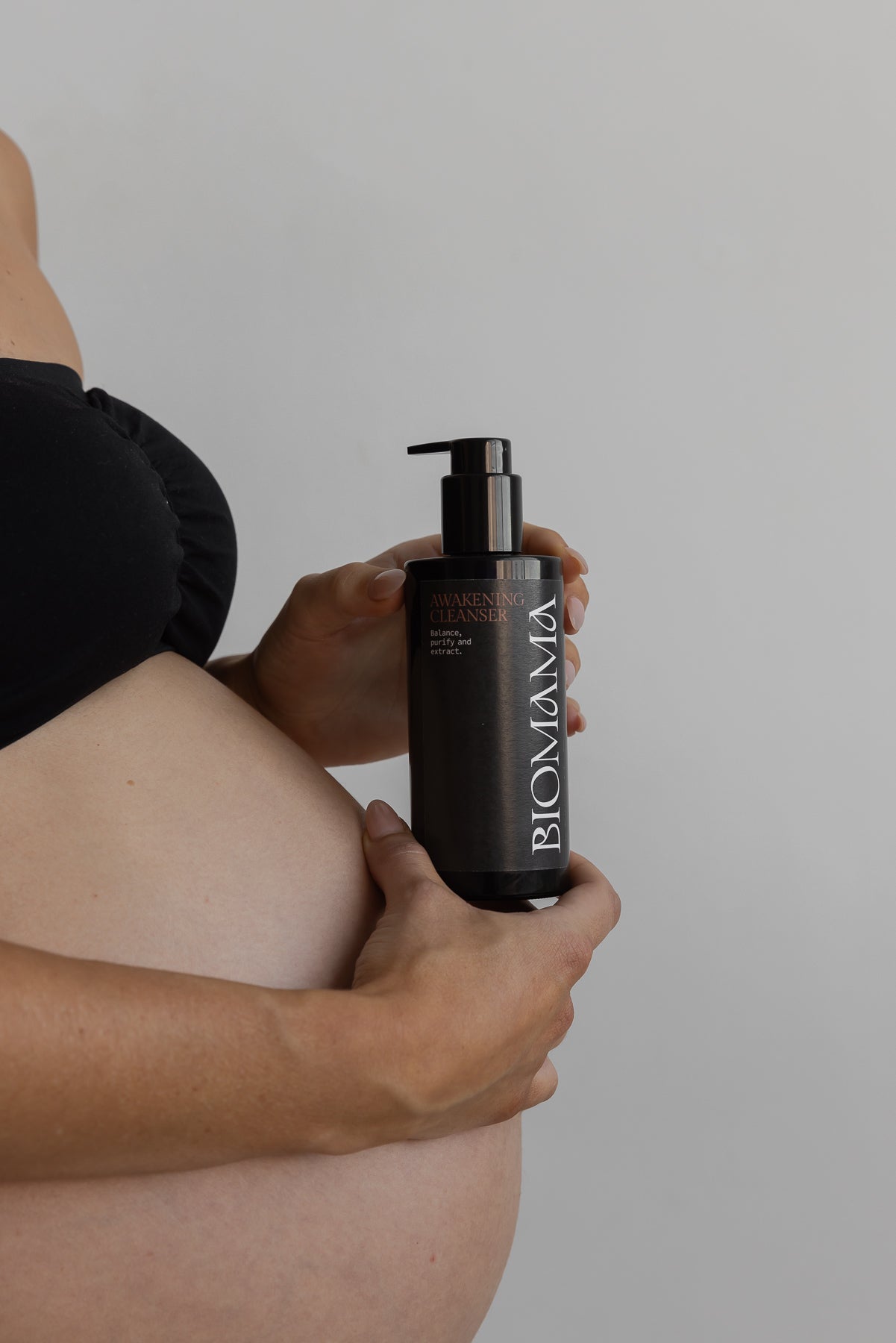 Pregnant woman holding Biomama Awakening Cleanser